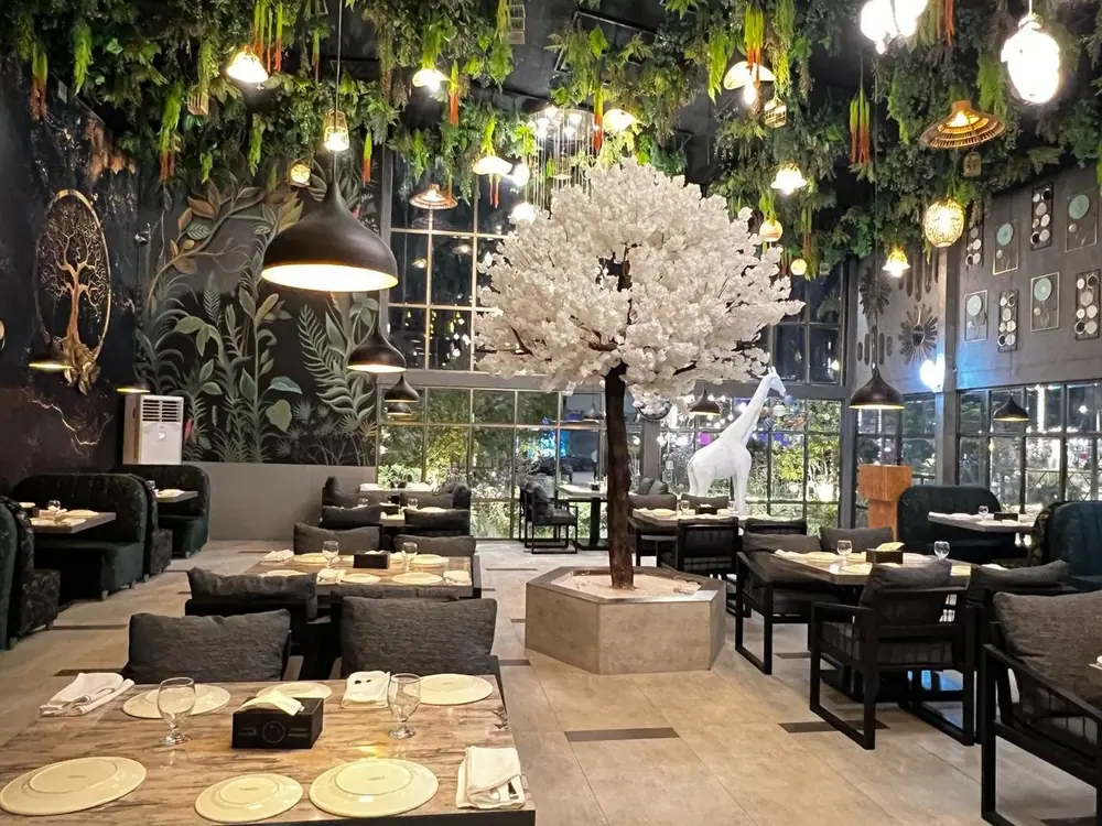 Saltanat's dining area styled with lush greenery and warm ambient lighting